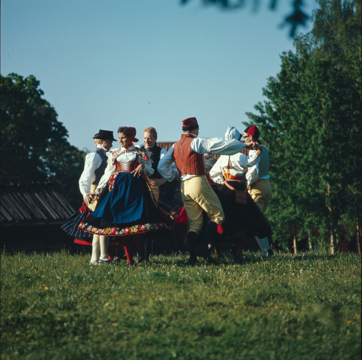 Ett folkdanslag dansar på Tingsvallens gräsplan.