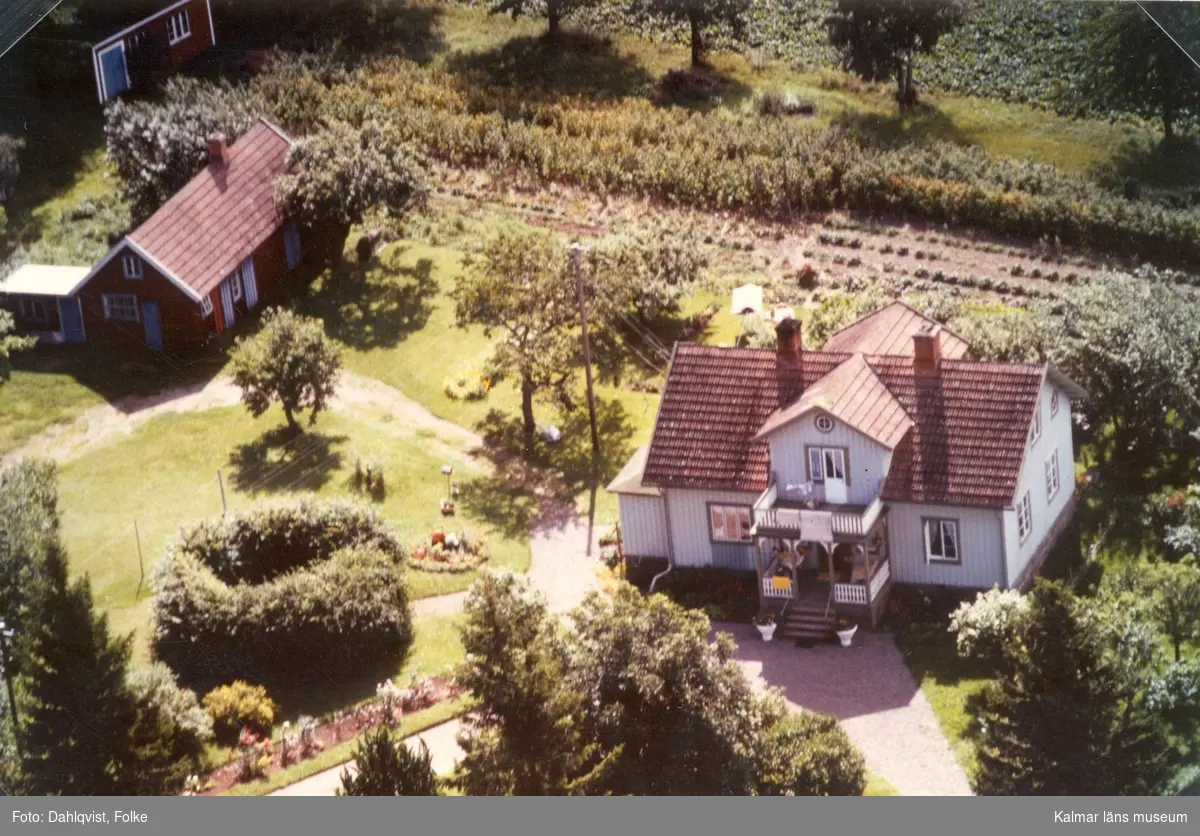 Ett bostadshus med sidobyggnad och trädgård i Arby socken.
