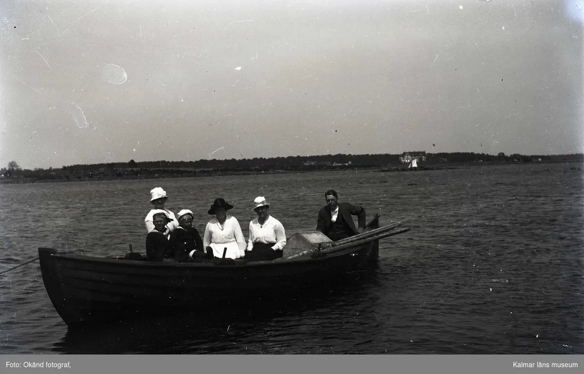 En man, tre kvinnor och två barn på en båtutflykt.