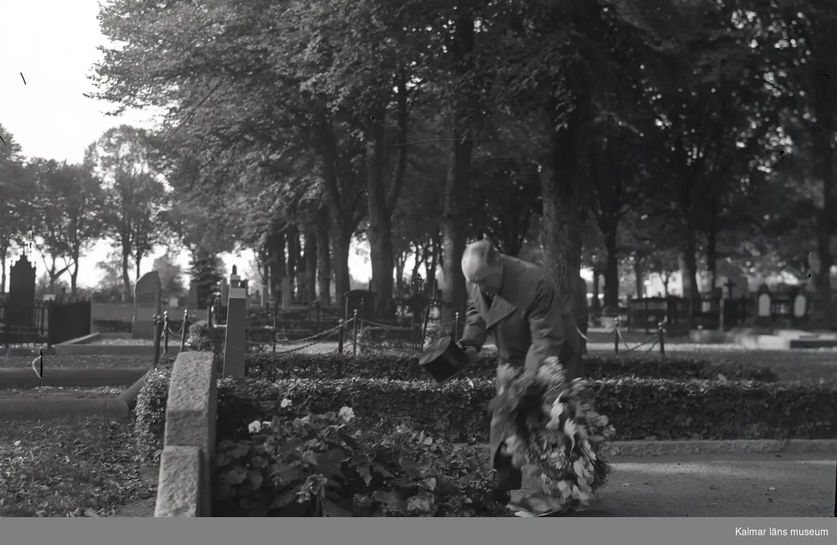 En man lägger ner en krans på den grav där några av de vid minsprängningen i Gräsgård 1941 omkomna sjömännen begravdes.