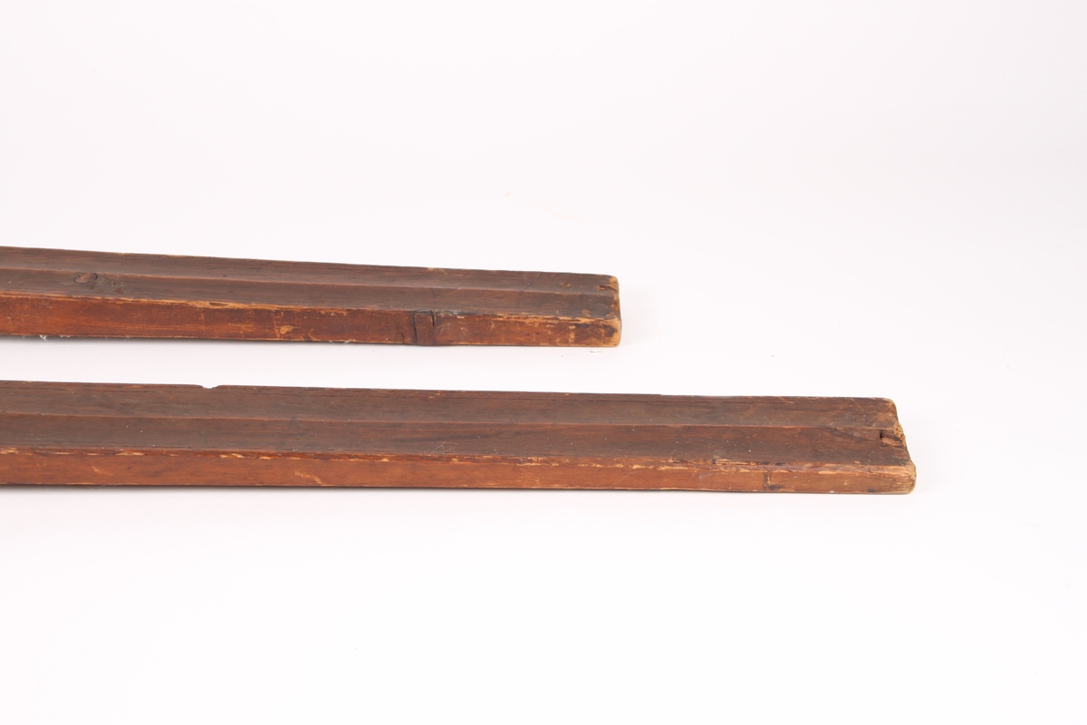 Et par treski i helved med avsmalnende framski og jevnbred bakski. Skiene har strekmåtdekor og svakt møne langs hele oversiden. Lang skitupp med geometriske innskjæringer på oversiden. Skienes bakende er plane og rett avskåret. Det er to bindingshull gjennom skien og fotstegplate på oversiden. Enkel rand under skien.