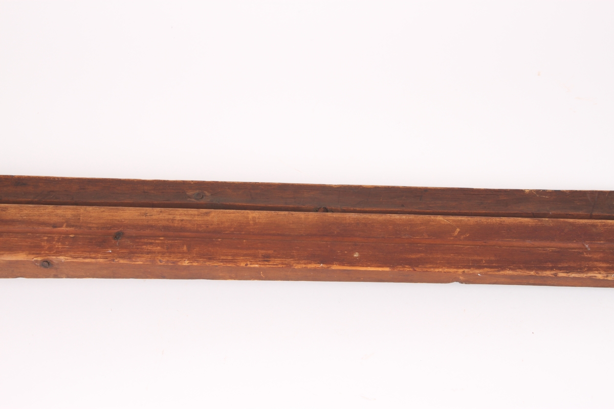 Et par treski i helved med avsmalnende framski og jevnbred bakski. Skiene har strekmåtdekor og svakt møne langs hele oversiden. Lang skitupp med geometriske innskjæringer på oversiden. Skienes bakende er plane og rett avskåret. Det er to bindingshull gjennom skien og fotstegplate på oversiden. Enkel rand under skien.