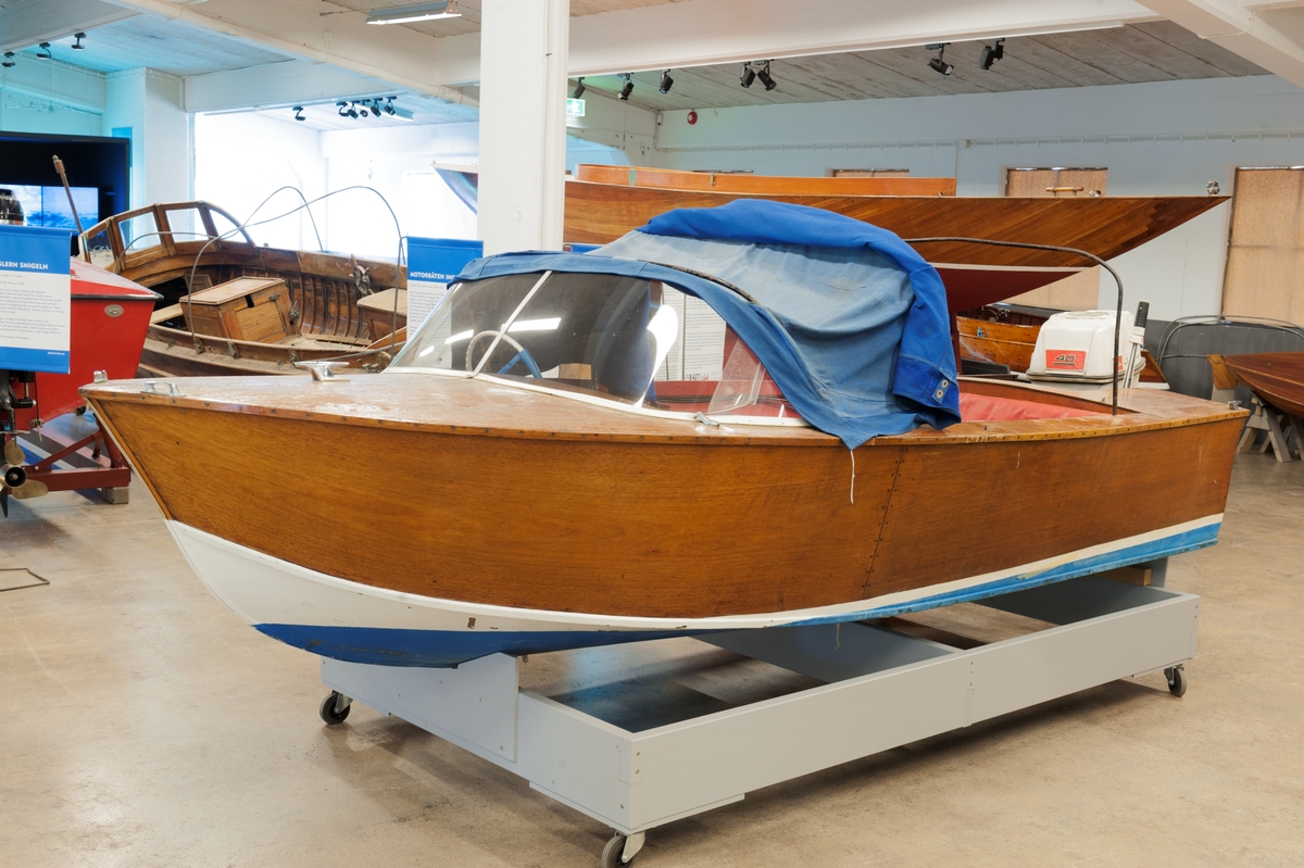 Sportbåt i mahognyplywood. Till båten hör en 40 hkr Johnsonmotor, trycktank, kapell med bågar och dynor.
