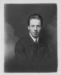 atelierfotografi av ung mann kledd i mørk jakke med kvit skj