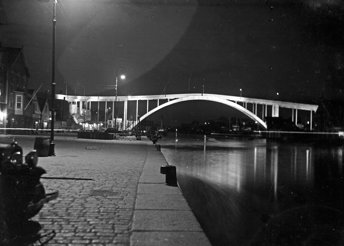 Kveldstemning på indre kai. Risøybroen opplyst i bakgrunnen.