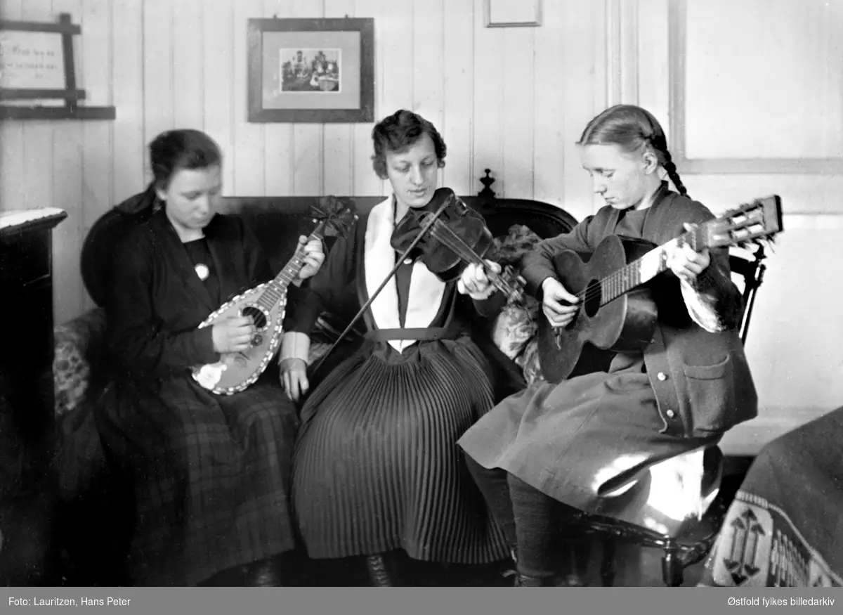 Musisering i stua på Hollenderbjerget i Moss ca. 
.1922-1925. Fotografens døtre, søstrene Lauritzen, musiserer i stuen sammen med sin kusine, Rakel. 
Fra venstre: Ingertha, Rakel og Solveig.
De spiller henholdsdvis; mandolin, fiolin og gitar.