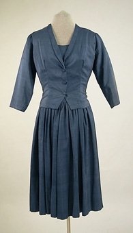Blå ärmlös klänning med tillhörande jacka 106163:2 av blått shantungsiden.
Blixtlås mitt bak.
Sydd av givaren på 1950-talet.