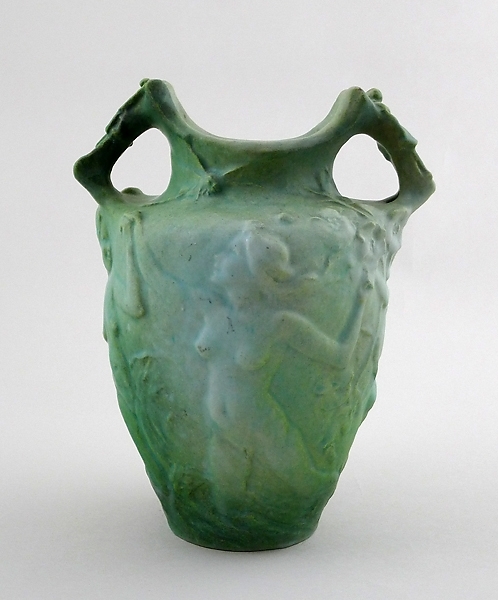 Urnformad vas med två handtag; grönpatinerad. På utsidan dekorerad med nakna figurer i olika åldrar.
Enl. liggaren föreställande de fyra åldrarna.

Märkt "de Frumerie. Scp teur". I botten "Lachenal  ceramiste"