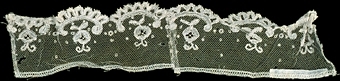 Manschett av vit tyll med mönster och uddar med söm på mitten.


Neg.nr: 1989-02