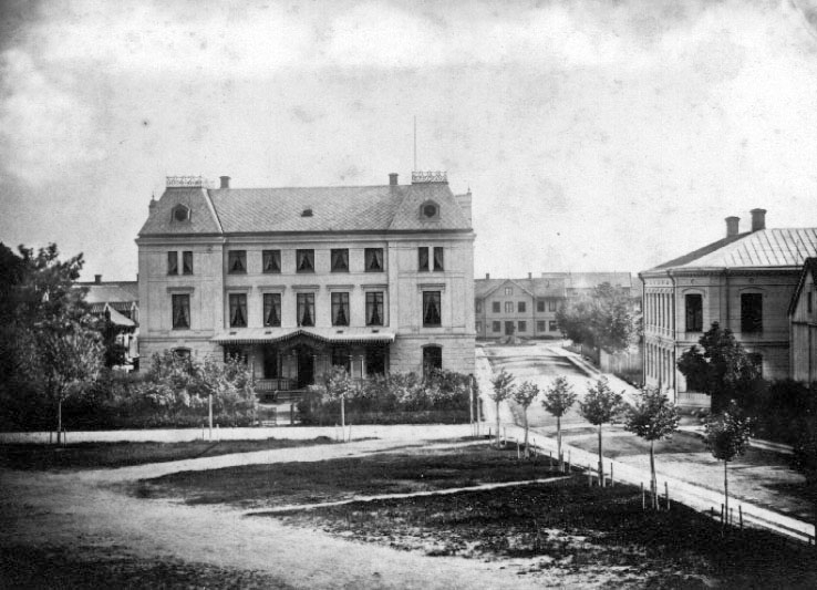 Skara.
Från skolgården: Hotellet, Stationshuset, "kåken med rakstugan och sedemera telegrafen, Järnvägsatan.