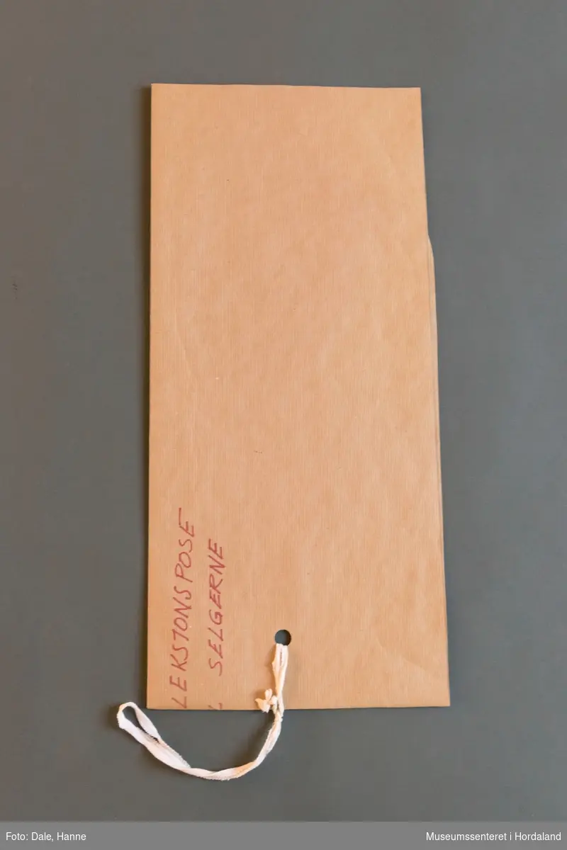 Mønsterskante i papp, brukt til å skjere ut ulike delar av plagg i klesproduksjon. Desse er til ein kolleksjonspose til seljarane.