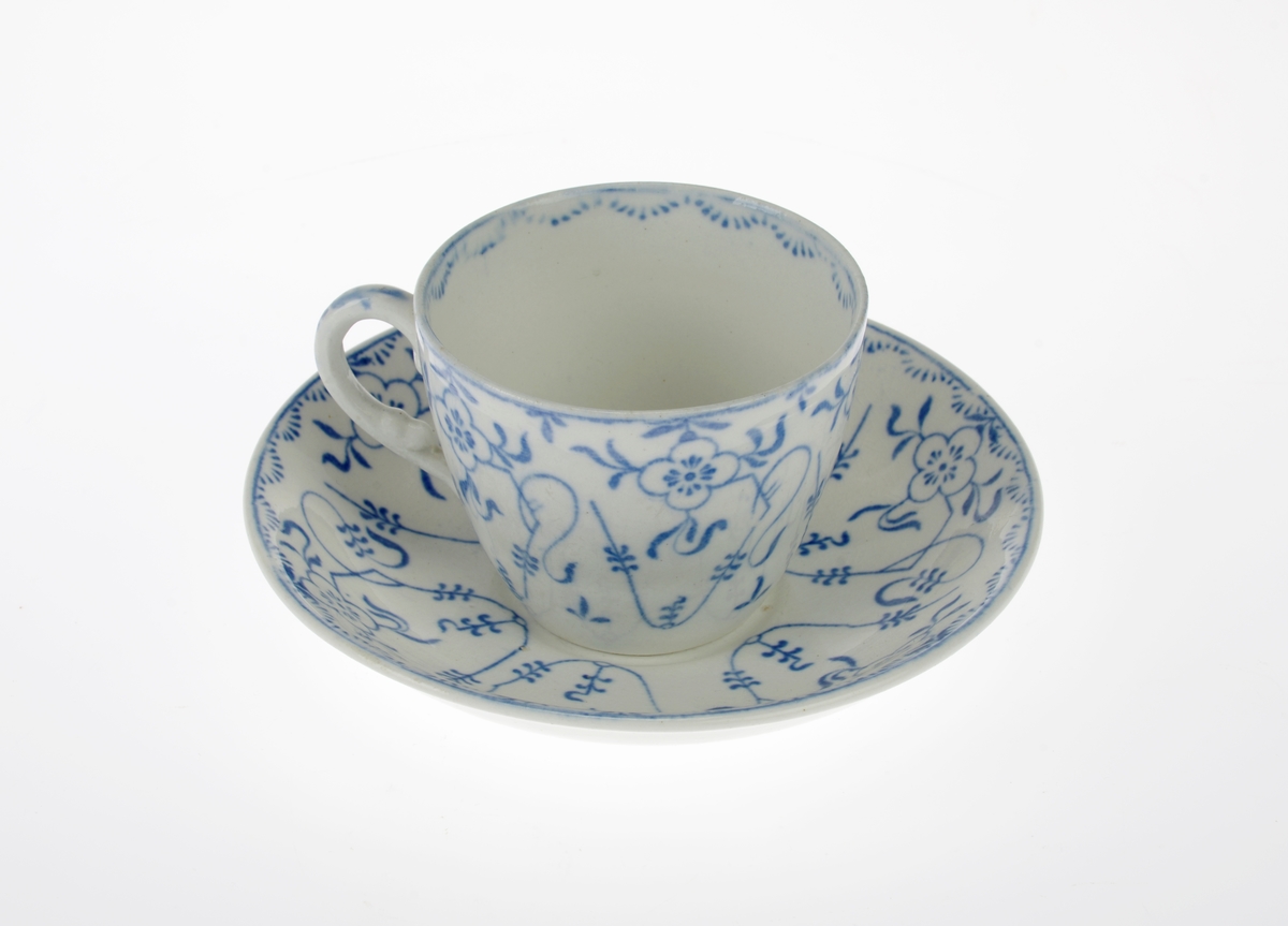 En kopp og to tefat av keramikk/porselen. Bunnfargen er hvit og det er dekor i blått. Dekoren er stråmønster. Det ene tefatet har en sprekk.