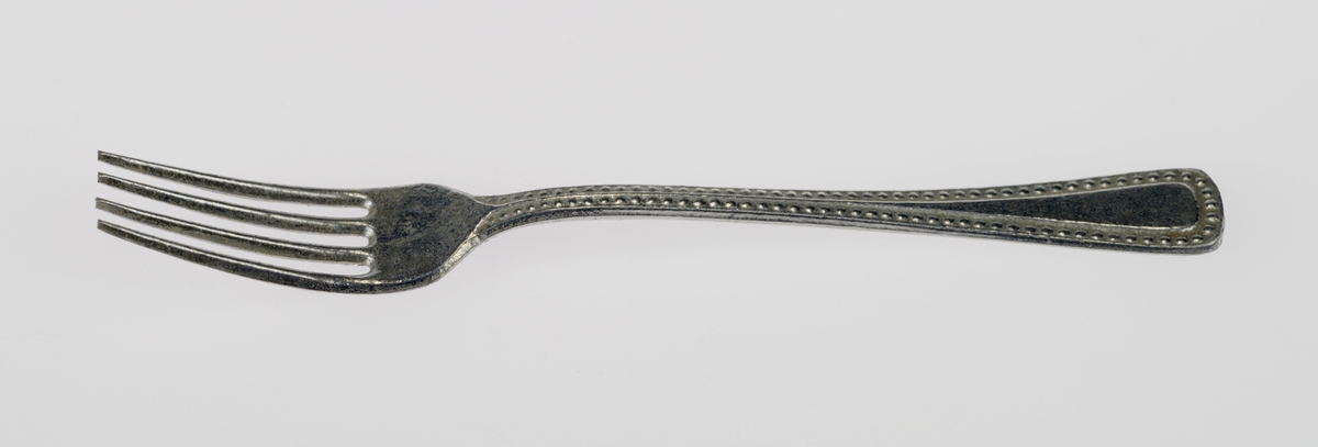 En liten bestikkurv med lekebestikk i. Alt er laget av metall. Gjenstandene er undernummerert 01-08, på de minste gjenstandene står kun undernummeret da det ikke var plass til hele FTT-nummeret.
FTT.54449.01: En trådkurv laget av blå metallnetting som er falset sammen med blankt metall. Bestikkurven har tre rom.
FTT.54449.02-03: To kniver med bredt blad og avrundet i enden. Skaftet har prikkmønster langs kanten og en opphøyet stripe i midten.
FTT.54449.04-05: To gafler med lik utforming men av ulik størrelse. Begge har fire tenner. På skaftet er det prikkmønster langs kanten og en opphøyet stripe på midten.
FTT.54449.006-07: To identiske skjeer. På skaftet er det prikkmønster langs kanten og en opphøyet stripe på midten.
FTT.54449.08: En liten øse med rundt hode. Skaftet er rundt før det blir flatt i enden. I endene er det også krokformet (for oppheng).