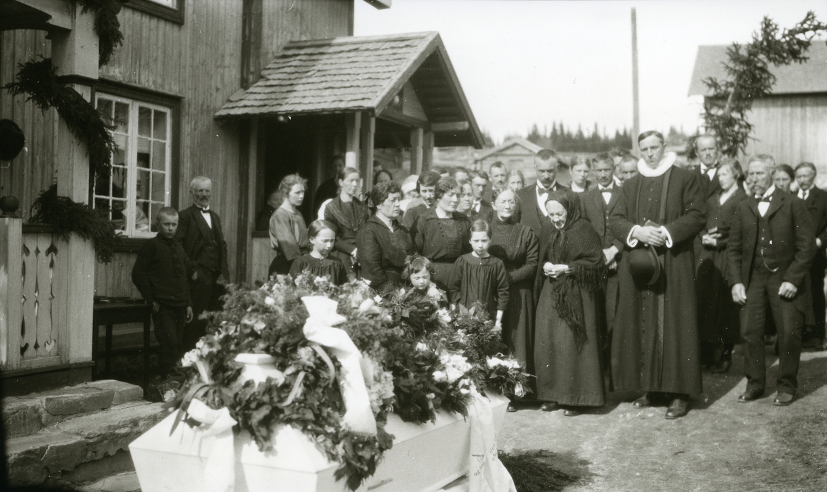 Folk forsamlet foran kiste utenfor Jons i Galåsen. Begravelsen til Magnus Galaasen (1878 - 1923). 
Prest: Finstad.