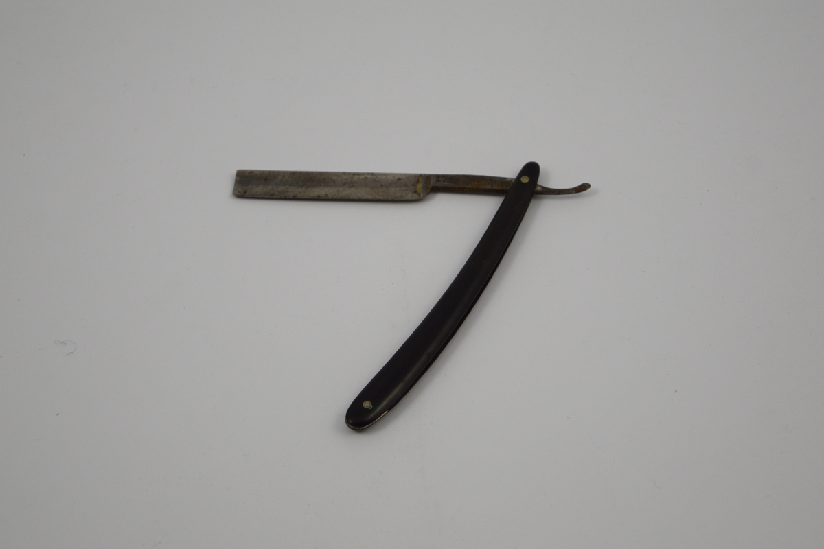 Sammenleggbar barberkniv med rett egg. Bladet munner ut i tynt skaft
med en krumning som holdegrep med fingeren. Skaftet er naglet fast til
kniven. Består av to deler, der den ene delen fungerer som beskyttelse for 
kniven i sammenlagt stilling.