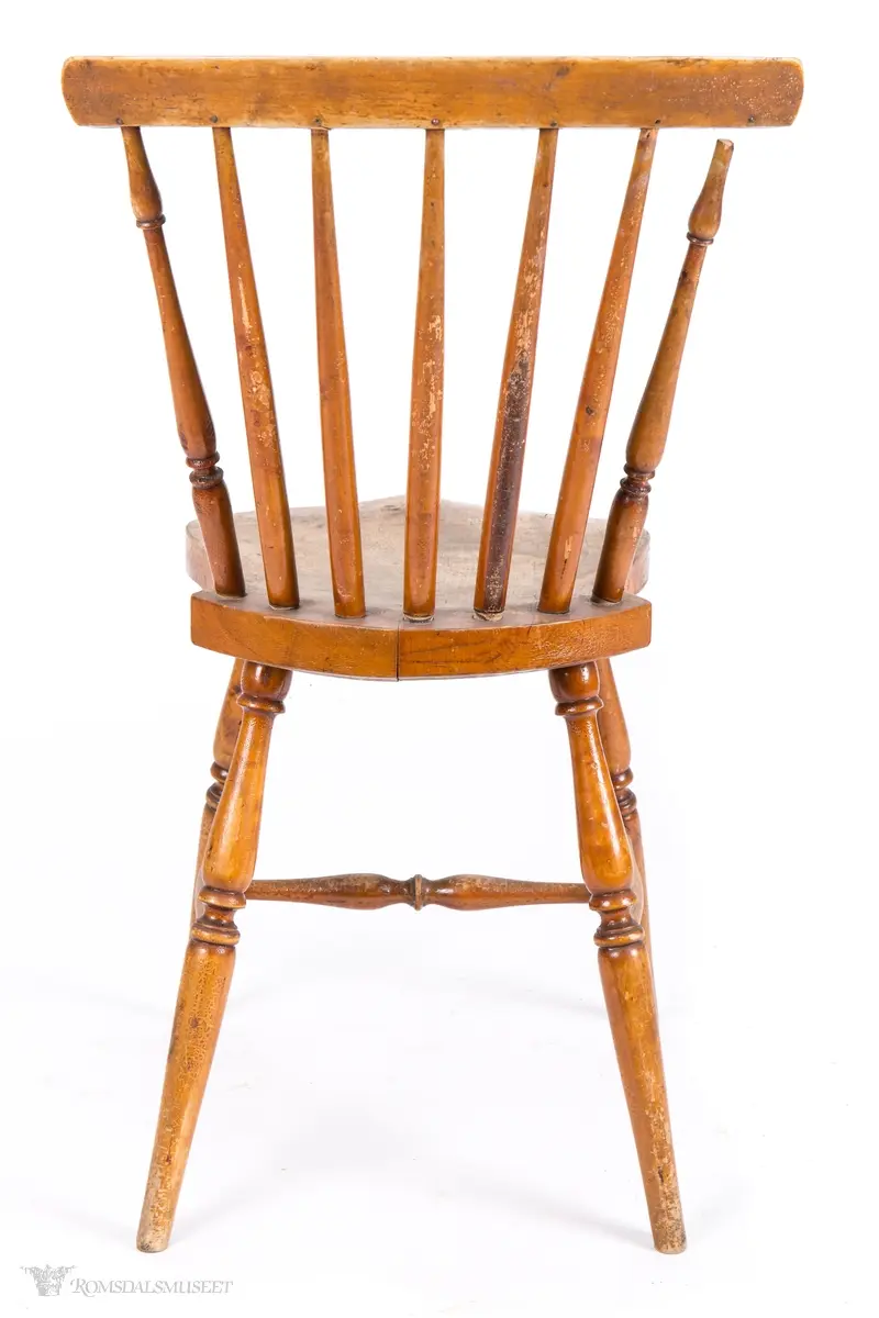 Pinnestol eller "Jønkjøpingstol" med kraftig skjoldformet sete med dreide ben med H- sprosse imellom. 7 pinner i ryggen, der de ytterste har dreide mønster, som går inn i et buet skulderbrett.