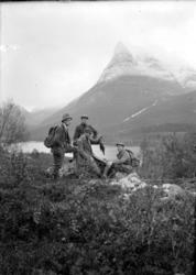 Fire menn på fjelltur/fisketur. Her samlet for å se på dagen