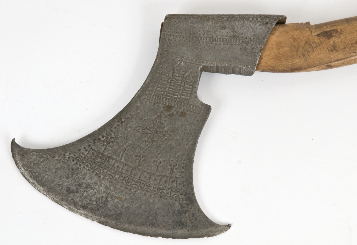 Asymmetrisk blad med lang øvre spiss og kortere nedre spiss. Bladet er klieformet. med avtrapping fra øksehammeren på den forsiden. Øksen har punslet dekor på begge sider. Øksen er merket med årstall 1653 og seks smedmerker på utsiden.
Øksehammeren har skaftehull
Ikke originalt, men gammelt skaft.Skaftet har doppsko med pigg og4 fliker
Skaftet er svakt krummet.