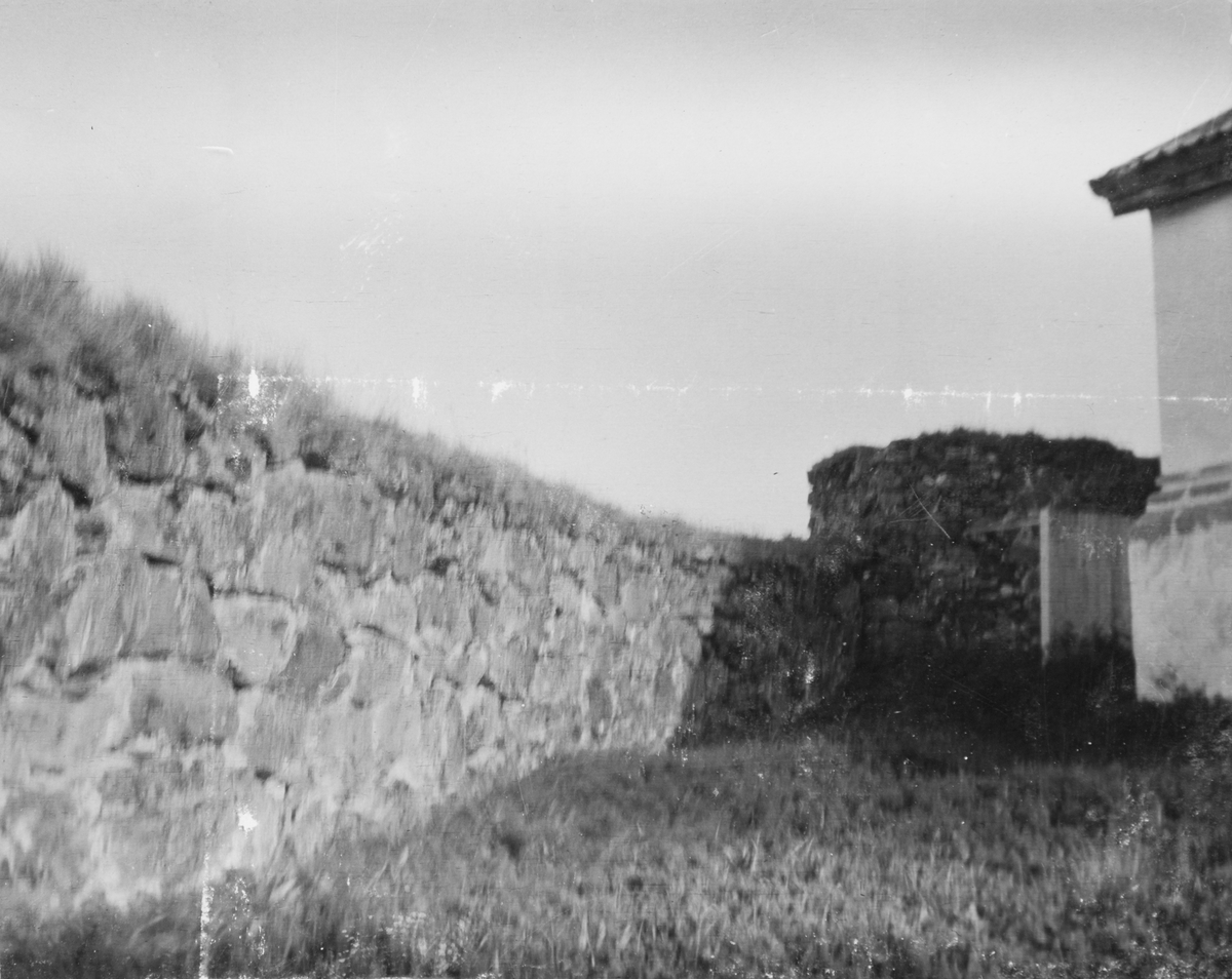 Parti av forsvarsmuren ved Trondeneskirka, med det nordre tårnet og hjørnet på kirka til høyre.