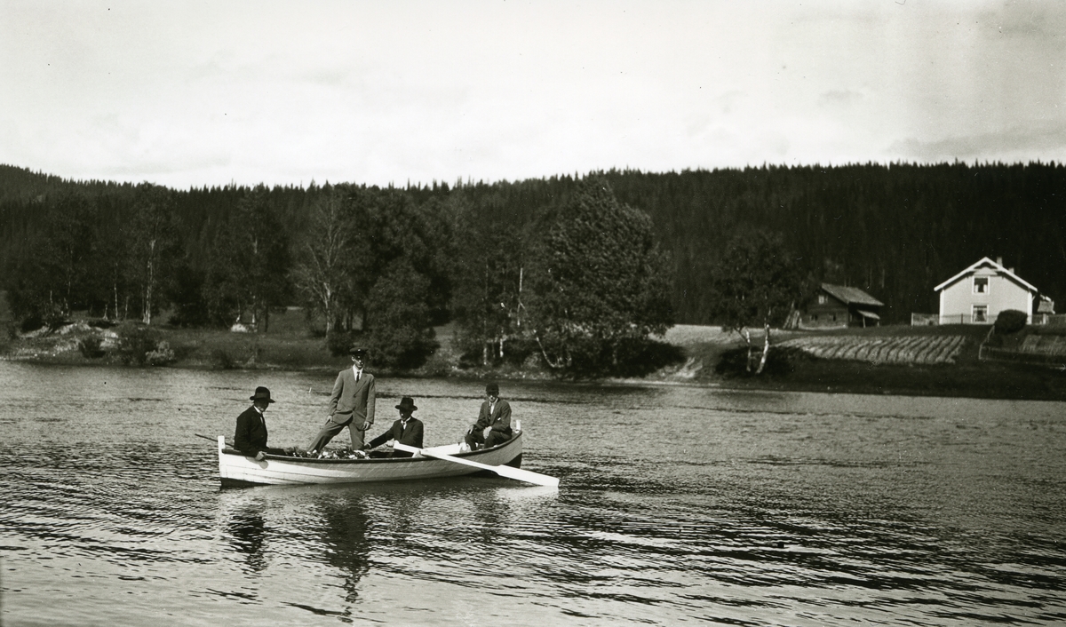 Likferd i båt. Fire menn på vei over elva ved Sætre (Hansgard)