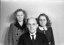 Halvfigurs portrett av en mann og to yngre kvinner. Ingen av