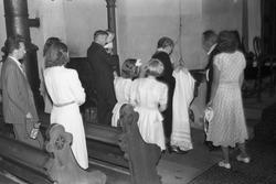 Dåpshandling i Hoff kirke. Personer samlet rundt døpefonten.