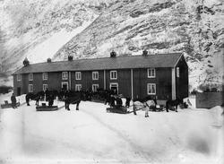 Folk og hestar med sleder i garden på Stor-Fale i samband me