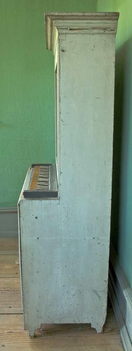 Orgel av trä, vitmålad, rak form. En pedal.