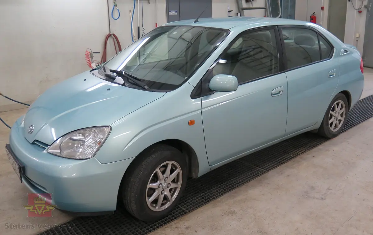 Hybrid, elektrisk/bensin drevet personbil med framhjulstrekk. 2-akslet. Den er en 4-seters sedan med 1,5-liters bensin- (58 hk) og 288 V elmotor (40 hk). Den hadde trinnløst gir (automat). Lys blå utvendig og grå innvendig. Sommerhjul(originale Toyota lettmetall felger) og vinterhjul (uoriginale felger på vinterhjul). Kilometerstand ca. 170.000 km.
Lite rust på karosseri (hull under venstre forskjerm), noe overflaterust på hjuloppheng. Interiør i god stand og lite slitt.  Har originalt hybridbatteri. En liten bulk under støtfanger bak.
OBDII leser montert bak rattet,