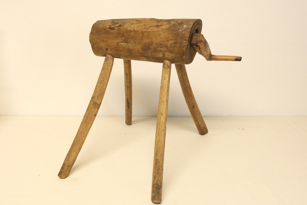 Potetkvern i tre. Kverna står på 4 bein av eik. Den er laget av hel ved. Skrue/Tregjenger/Kall inni hulrommet, påmontert ei sveiv på utsiden.