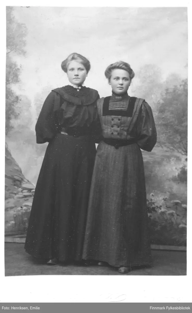 Portrett av to ukjente kvinner. De er begge kledd i kjoler med belter rundt midjen. Begge har pyntet seg med brosjer i halsen på blusen.