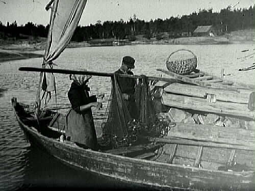En pojke och en flicka reder fiskenäten (garnen) i en segelbåt.
(Bild 1: F211; Bild 2: E5299)