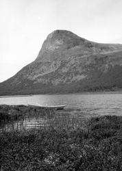Sikkilsdalshornet m/ vannet og båt i forgrunnen.