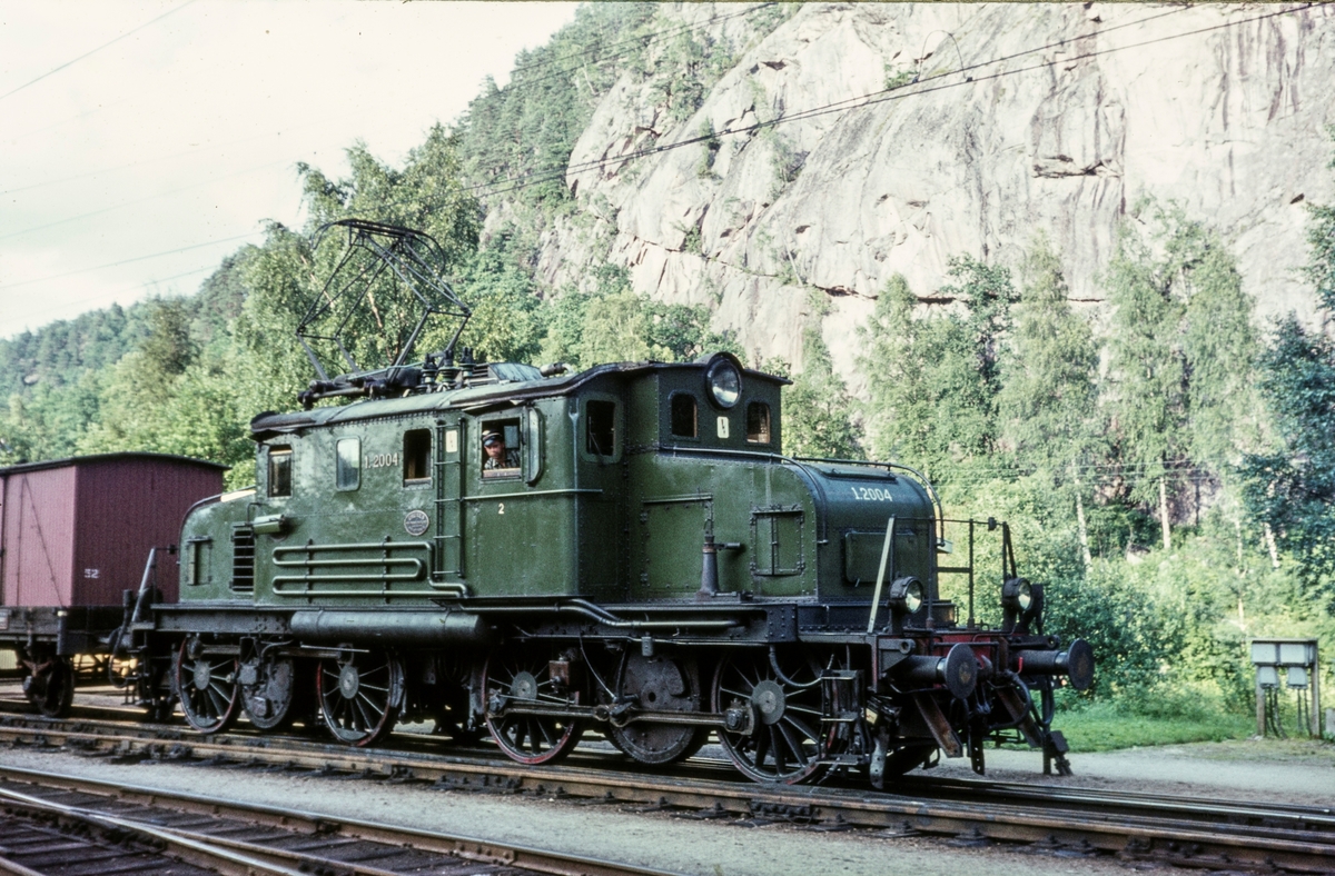 Godstog retning Kristiansand på Grovane stasjon. Toget trekkes av elektrisk lokomotiv type El 1 nr. 2004.