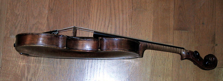 Fiolinkasse (a), folin (b) og bue (c). Kassen er i lær. Åpning i begge ender. Hemmelig rom i toppen. Preget dekor i læret. Kassa har lås. Fiolinen er god, kassen er slitt