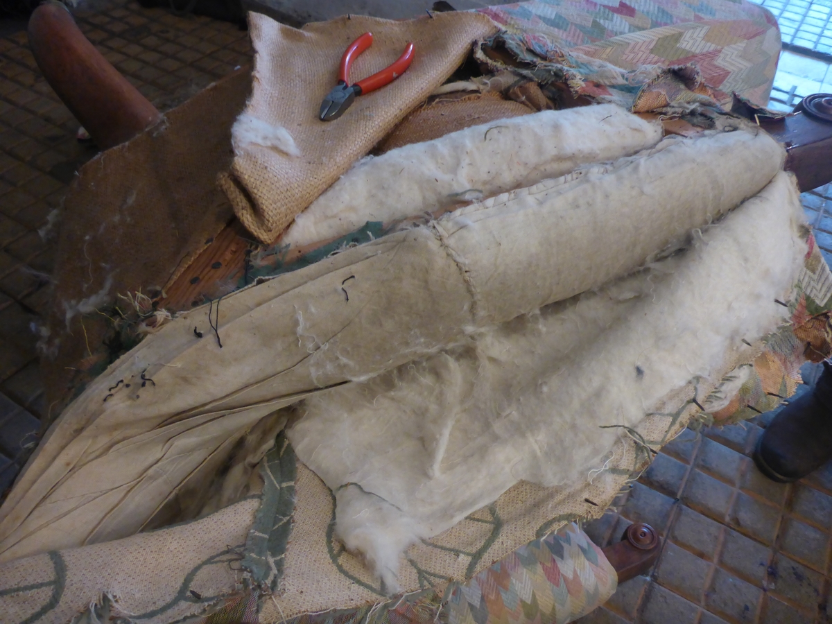 Stolen har en ramme av tre med dreide frambein som er beiset og oljet.