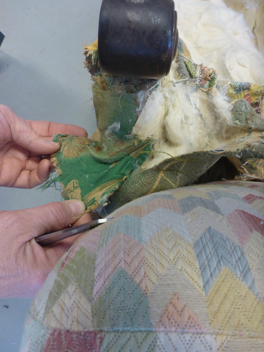 Stolen har en ramme av tre med dreide frambein som er beiset og oljet.