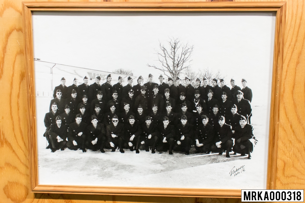 Fotografi taget på befäl och soldater som genomfört grundläggande soldatutbildning på 1:a Batteriet KA 2.
Fotografiet taget på Rosenholm KA 2.
Flobergs Foto 1986.
