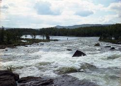 En fisker som står i elva mellom Veslevatnet og Tisleifjorde