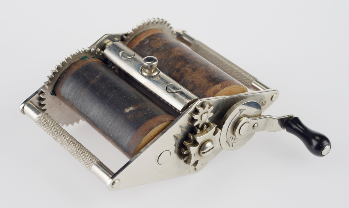 Roterende slipere i tre med sveiv. Ligger i en svart plast eske med lilla stoff på innsiden med bruksanvisning.