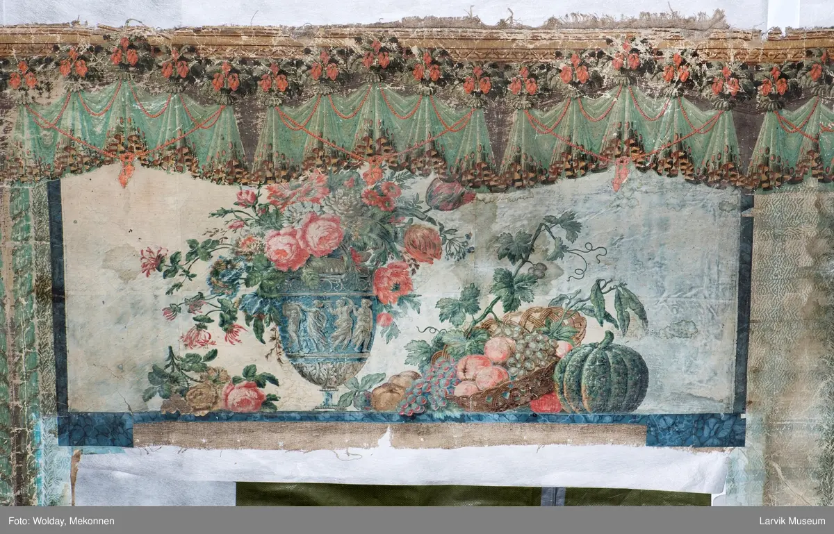 |Tapeten er påmalt tapetborder og brystning. Fra Hovland gård i Larvik.
Den øverste, brede borden: Gerlander/draperi med blomsterranker.
Den nederste, smalere borden: Tekstilbord med blomster. Øver døren til høyre: Stillebenmotiv med blomster og frukt.