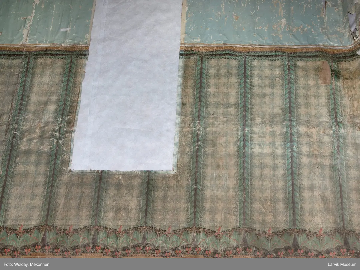 |Tapeten er påmalt tapetborder og brystning. Fra Hovland gård i Larvik.
Den øverste, brede borden: Gerlander/draperi med blomsterranker.
Den nederste, smalere borden: Tekstilbord med blomster. Øver døren til høyre: Stillebenmotiv med blomster og frukt.