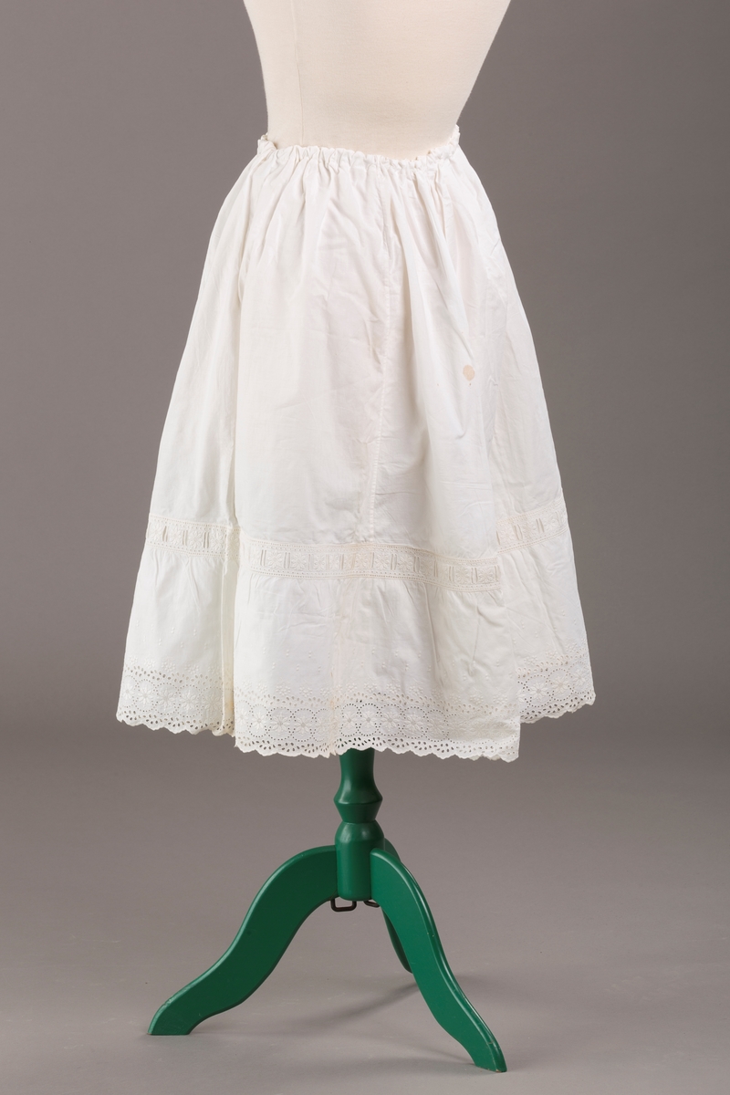 Form: Sydd sammen av seks høyder av ulik bredde og skjæring, blondekant, hullsøm, strikk i livet,