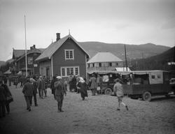 Folkemengde og lastebiler på Gol jernbanestasjon.