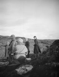 En gruppe av 6 mennesker med hatt og frakk på fjellet.