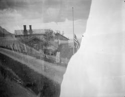 Hus med flagg på halv stang. Ikke bilde på ene halvdel.