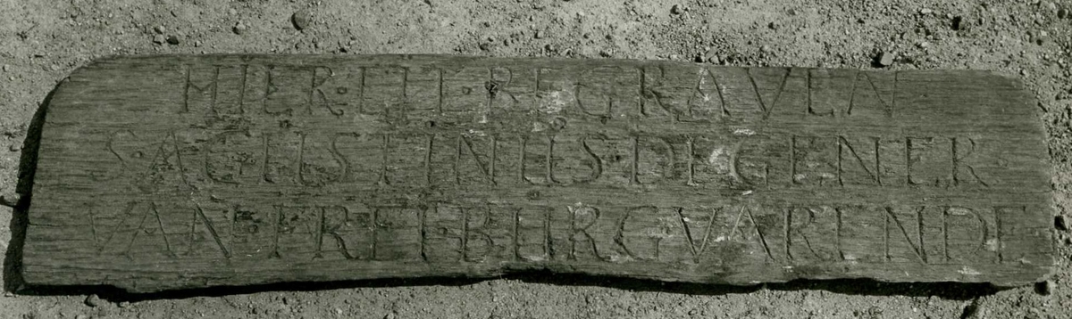 Fragment av trätavla med inskription.