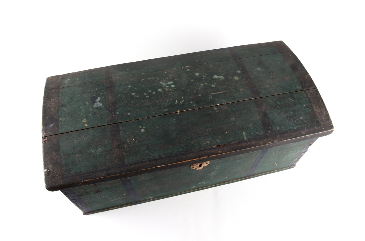 Grønnmalt trekiste med hjerteformet låsbeslag skåret ut i tre. Lås og hengsler i metall. Kisten har leddik med lokk innvendig.