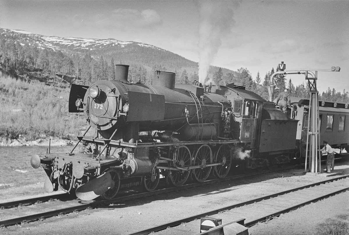 Dagtoget fra Trondheim til Oslo Ø over Røros, tog 302, fyller vann på Langlete stasjon. Toget trekkes av damplokomotiv type 30a nr. 272.