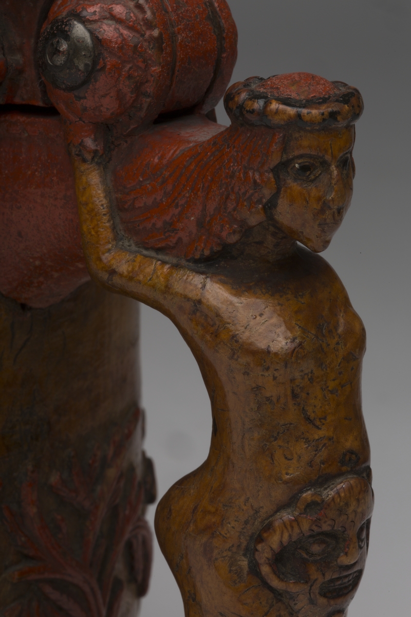 Dekorert med fortløpende billedfrise med dyr og trær på nederste del av korpus. Kannen har løveføtter og løvegjekk og bakkantine som håndtak. 